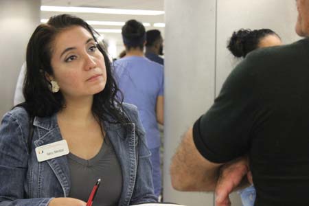 Nancy Mendoza, a Miami Law L.L.M. student from Venezuela, interviews a Cuban resident in Miami as he waits for family to arrive from Havana at the Miami International Airport.