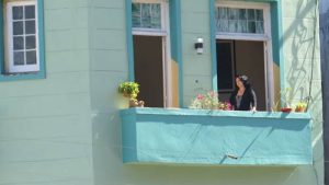 A woman peers from a balcony in downtown Havana, Cuba.